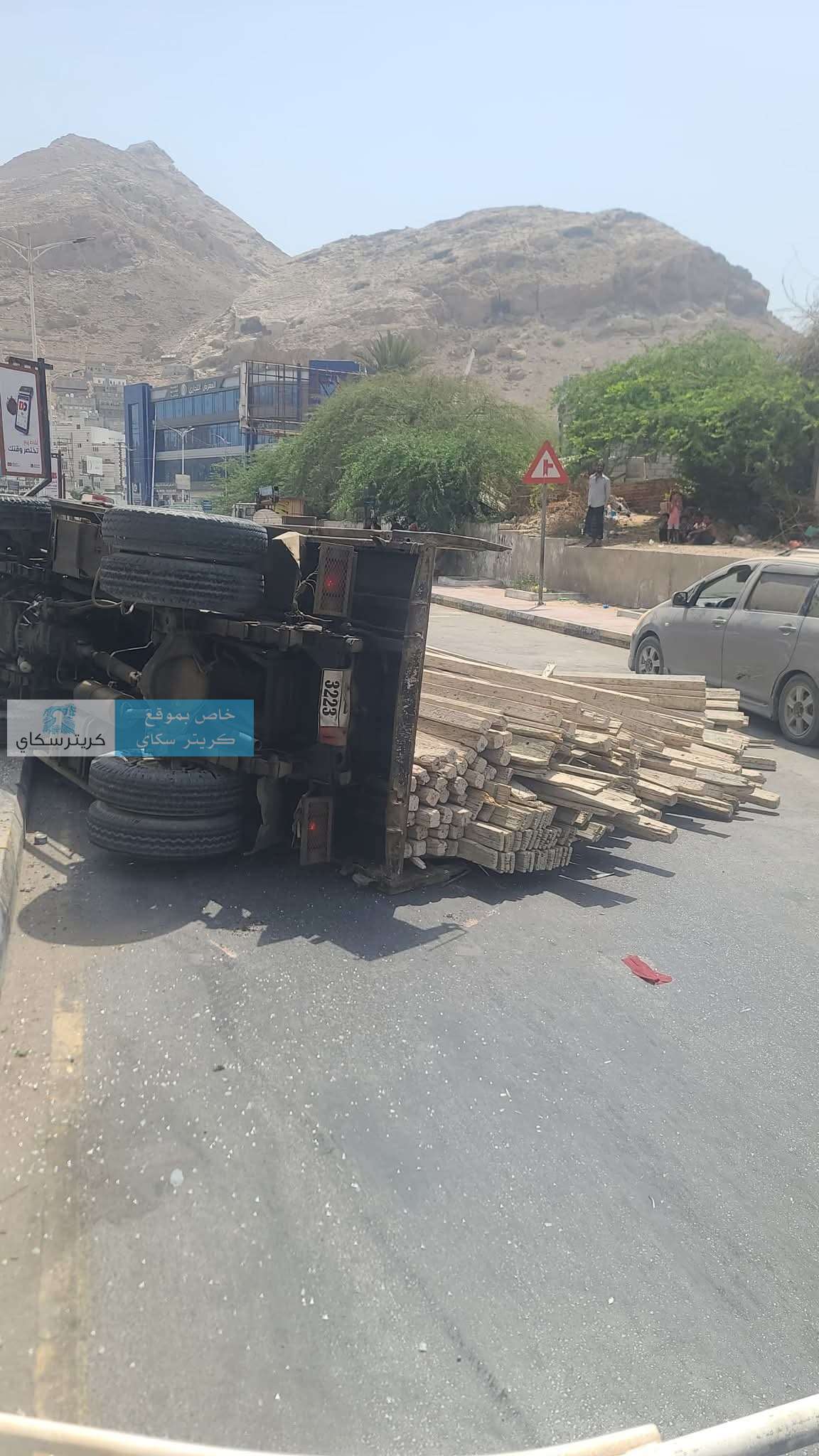 نجاة مواطنين بأعجوبة بعد انقلاب شاحنة أخشاب وإغلاق طريق حيوي